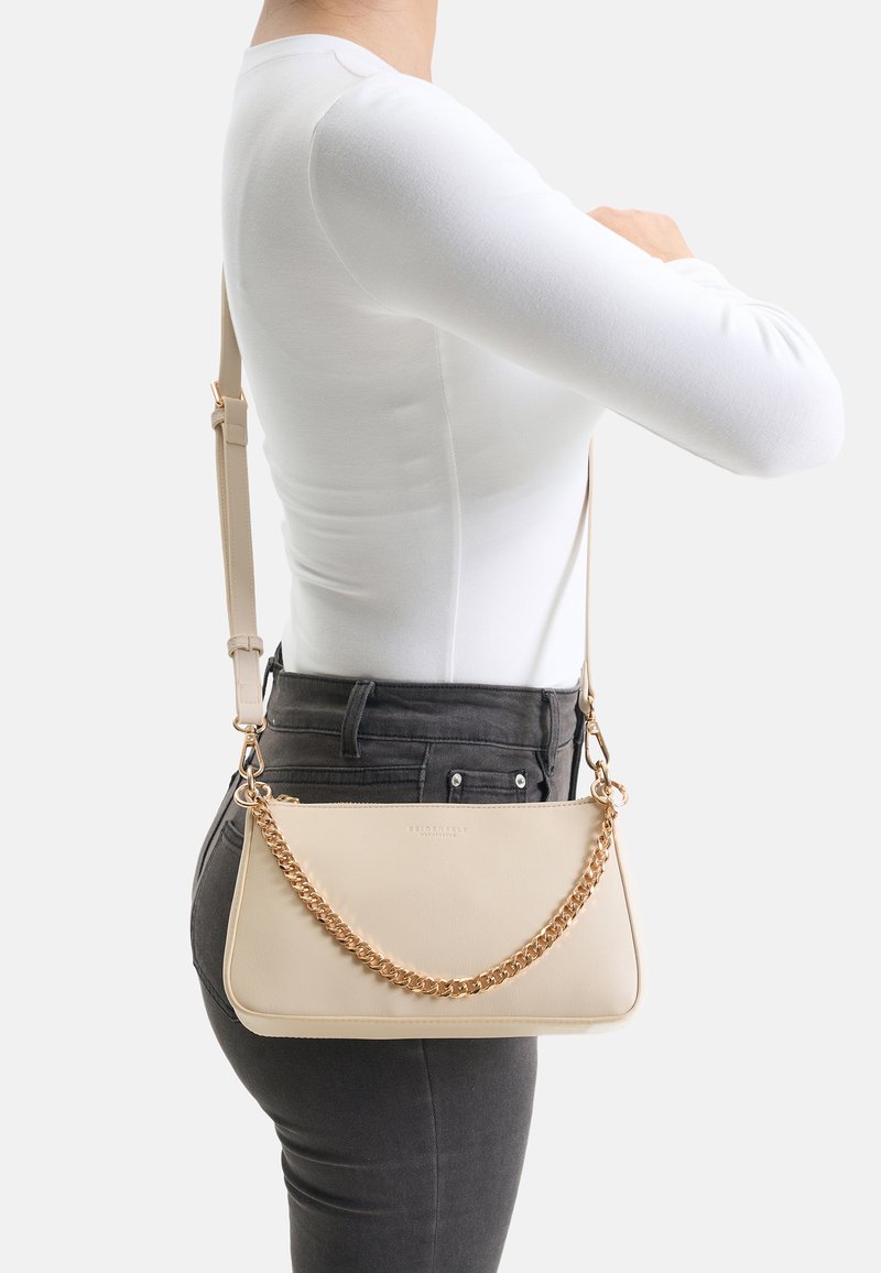 Beige Umhängetasche aus glattem Leder mit einer goldfarbenen Kettenakzent. Rechteckige Form mit weicher Textur und verstellbarem Riemen.