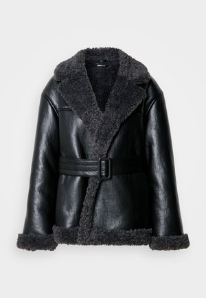 Black leather shearling coat with a wide collar, textured gray lining, front buckle belt detail, and plush cuffs.