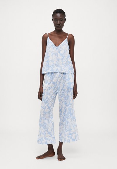 Conjunto de roupa de lazer com padrão floral em azul claro, apresentando um top sem mangas com decote em V e calças de perna larga. Tecido macio com uma textura suave.