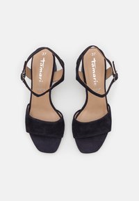 Svarta mocka högklackade sandaler med öppen tå, med ett korslagt ankelsnöre och ett brett framband. Storlek 37 synlig på innersulan.