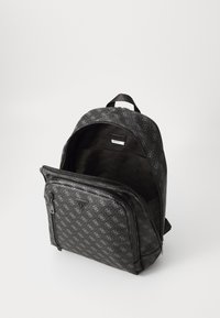 Sac à dos noir avec un motif logo sur toute sa surface, doté d'une poche zippée à l'avant et d'une poignée supérieure. Tissu texturé et intérieur spacieux.