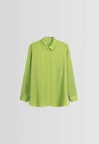 Camicia verde a maniche lunghe con colletto, realizzata in un tessuto testurizzato con un motivo sottile. Vestibilità su misura con orlo arrotondato.