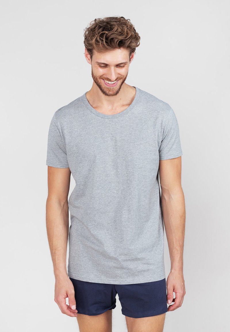 Grijze korte mouwen t-shirt van katoen, met een ronde halslijn en een gladde textuur. Draagt met donkerblauwe shorts.