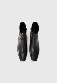 Black leather ankle boots with a squared toe, sleek design, and side zippers for easy wear. Smooth texture and minimalistic stitching details.