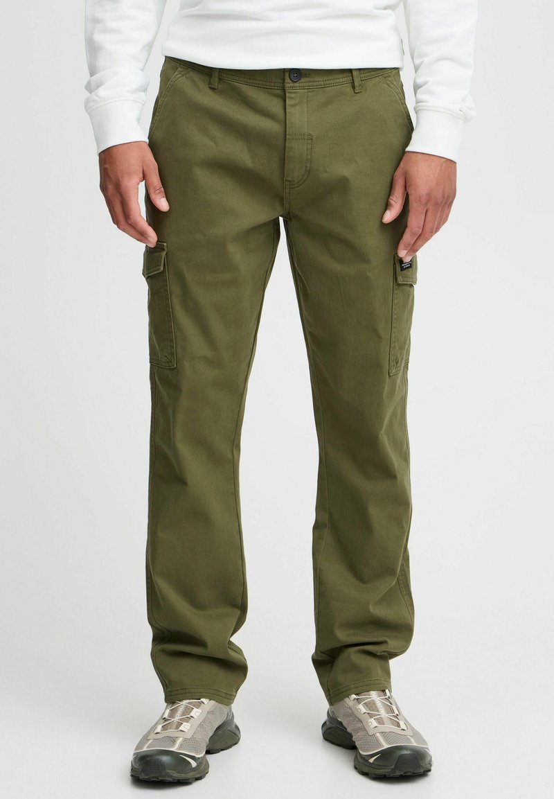 Khaki cargo pants made of cotton, featuring side pockets, a straight leg design, and a button closure, paired with gray athletic shoes.