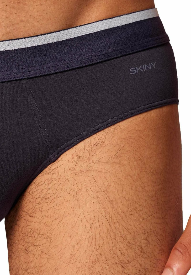 Slip in tessuto grigio scuro con cintura elastica di contrasto grigio chiaro, caratterizzati da una superficie liscia e un discreto dettaglio del logo.