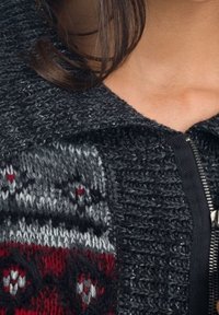 Šedý pletený svetr se zipem, ozdobený vzorovanou tkaninou v červené a šedé barvě a texturovaným límcem.