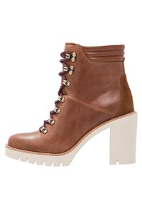 Bottine en cuir marron avec un talon carré, avant lacé avec des œillets métalliques et des lacets violets contrastants. Accents texturés sur le talon.