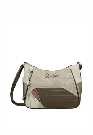 Bolso de hombro en beige, crema y marrón con la marca "Anekke", un charm de metal y la frase "learning no limits" en el frente.