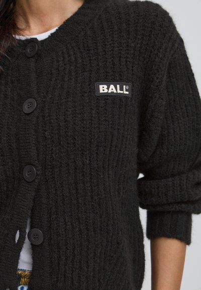 Cardigan negru tricotat, cu un model ondulat, guler rotund, butoane negre și un etichetă albă cu "BALL" pe partea stângă.