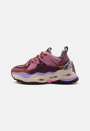 Zapatilla gruesa en rosa, morado, marrón y beige con suela gruesa, cierre de cordones en la parte delantera y pestañas para tirar en la lengüeta y el talón.