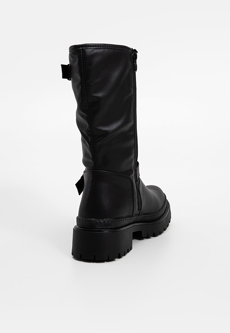 Stivale nero al ginocchio realizzato in pelle sintetica liscia, con zip laterale, suola in gomma spessa e tacco leggero.
