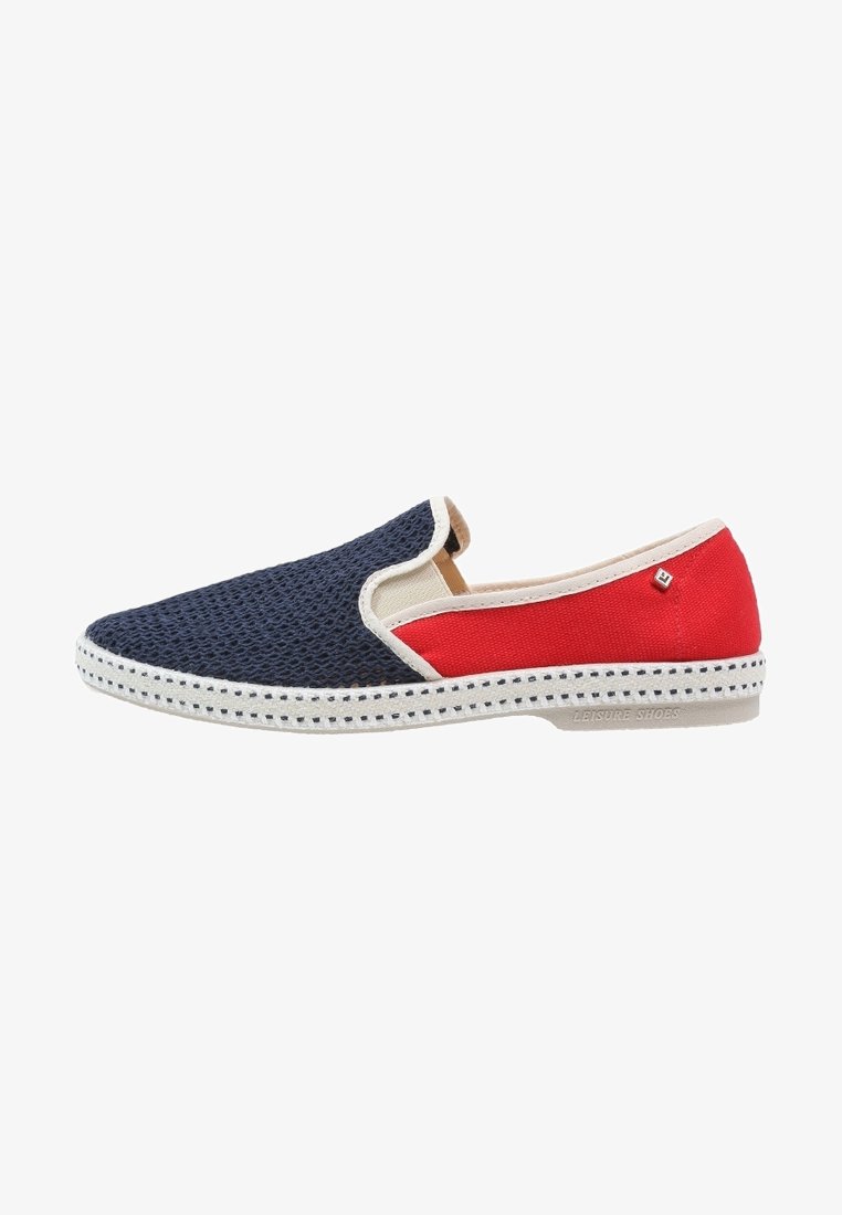 Chaussure slip-on avec une avant en maille marine, un arrière en tissu rouge, des garnitures blanches, et une semelle blanche avec un motif de points noirs.