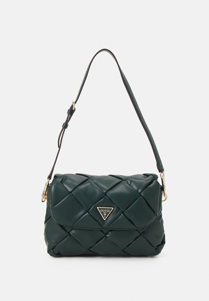 Sac à bandoulière en cuir matelassé vert foncé avec une sangle réglable et une plaque triangulaire dorée avec le logo Guess sur le rabat avant.