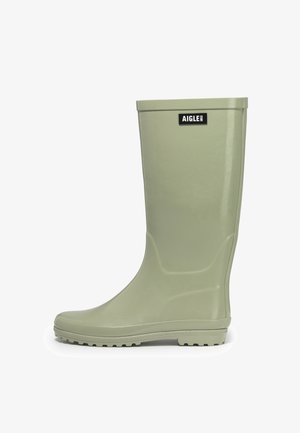 Green rubber rain boot with a smooth texture, high shaft, and a chunky outsole. Features a black logo label on the front.