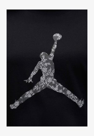 Black t-shirt featuring a white lace-patterned Jumpman logo. The design showcases intricate floral details within the logo.