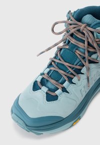 Lys blå treningssko med mesh- og skinn-overdel, med intrikat snøresystem, polstret krage og Vibram-såle for godt grep.