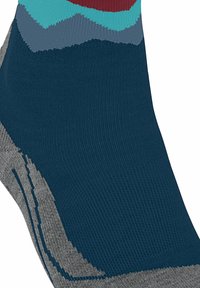 Primo piano di una calza multicolore con una base blu navy adornata da motivi geometrici in teal, grigio e bordeaux nella parte superiore.