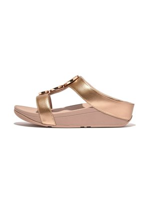 Sandales métalliques dorées avec deux larges brides, ornées de quincaillerie décorative. Semelle rembourrée en beige clair, légèrement surélevée au talon.
