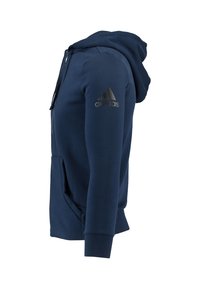 Sudadera con cremallera de color azul marino en tejido suave, que cuenta con un bolsillo frontal y una capucha texturizada. Logo de "Adidas" en negro en el hombro izquierdo.