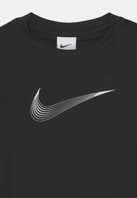 Svart T-shirt med en vit Nike swoosh-logotyp som består av flera kurviga linjer, synlig rundhals och sydd etikett vid kragen.