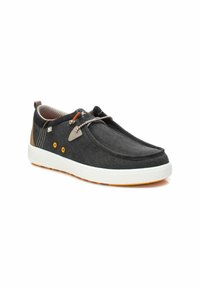 Zapatos negros de tela tipo slip-on con suela blanca, acentos en naranja y gris, superficie texturizada y detalles en contraste en color marrón claro en el talón.