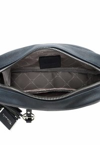 Sort lynlås læderpung åbnet for at vise gråt mønstret stofinderside med lille lomme og sort mærkat indeni.