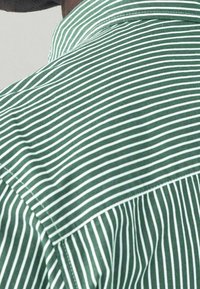 Zielona i biała w paski koszula z klasycznym kołnierzykiem, o gładkiej bawełnianej teksturze i precyzyjnym wykończeniu brzegów.