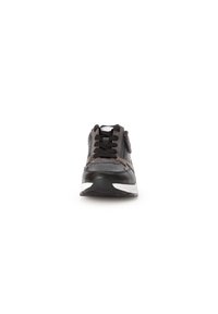 Zwarte en grijze sneaker met een gestructureerde bovenkant, vetersluiting en een zijrits, voorzien van een contrasterende witte zool en gedetailleerde stiksels.