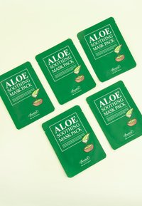 Cinque confezioni verdi di "Aloe Soothing Mask Pack" con un'illustrazione di foglia, testo frontale, texture liscia, disposte in un layout piatto.