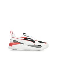 Sneaker Puma con tomaia in mesh bianco e dettagli neri e rossi, suola intermedia testurizzata e suola in gomma. Include un tassello sul tallone.