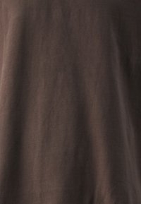 Brun bomullströja med en mjuk textur, med korta ärmar och en klassisk rundad halsringning. Minimalistisk design utan andra dekorationer.