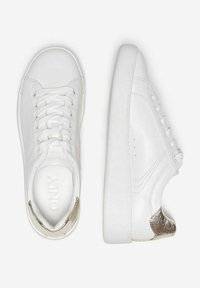 Baskets blanches avec un dessus en cuir lisse, bout rond et un accent de talon métallique texturé. Lacets et détails de couture minimalistes présents.