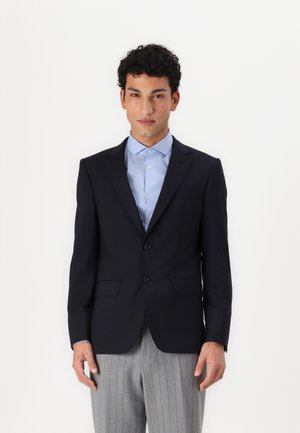 Navy blazer with notch lapels, two buttons, and side pockets. Paired with a light blue shirt and grey pinstriped trousers.