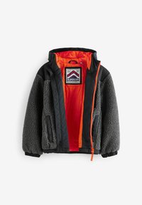 Giacca in pile grigia con dettagli in tessuto nero, rivestimento interno arancione e chiusura con zip. Presenta polsini elastici e un'etichetta con logo all'interno.