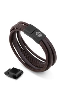 Bracelet made of braided brown leather with a smooth texture and a rectangular black metal clasp featuring a lotus design.
