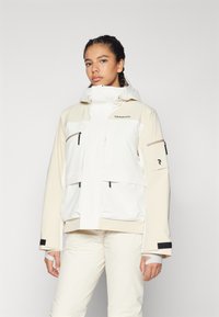 Hvid og beige vandtæt jakke med hætte, lynlåslommer og velcro-manchetter. Har en frontlynlås og et sporty design.