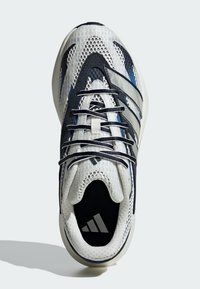 Bijela i mornarsko plava tenisica s mrežastim gornjim dijelom, crnim detaljima, teksturiranim potplatom i vezicama. Ima dizajn s tri pruge i jastučić za potporu uložaka.