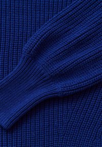 Pull en maille bleu avec une finition texturée. Il présente des poignets et un corps côtelés, mettant en valeur une couleur profonde et riche ainsi qu'un motif horizontal.