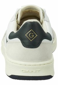 Weißer Sneaker mit grauen und marineblauen Akzenten, ausgestattet mit einer strukturierten Gummisohle, Wildleder- und Lederstoffen sowie einem goldenen, diamantförmigen Logo an der Ferse.