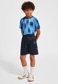 Blå och lila randig kortärmad sporttröja med svarta shorts, utrustade med resår i midjan och logotyp. Vita sockor och sportskor.