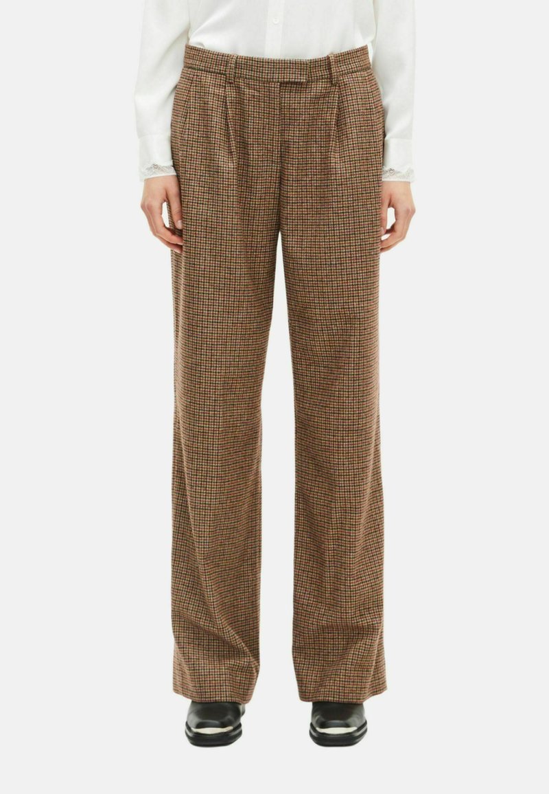 Brune og beige ternede bukser med brede ben, folder i taljen, lavet af textured stof, parret med sorte sko.