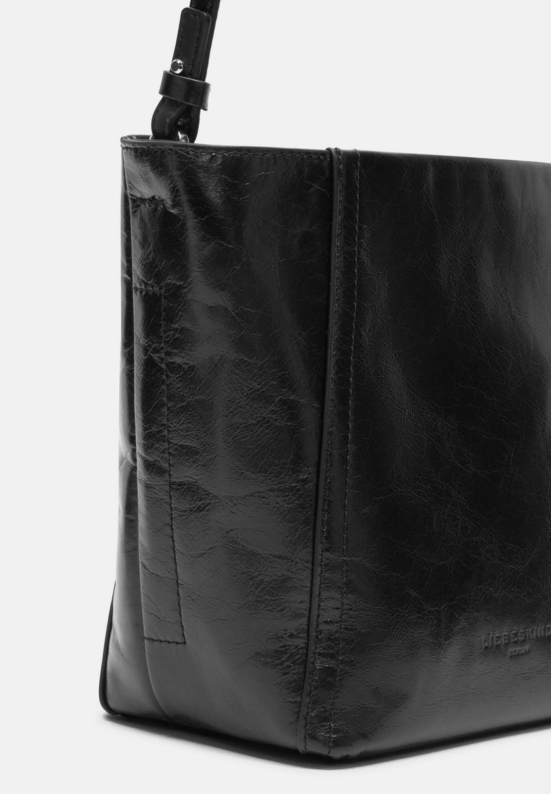 Schwarze Lederhandtasche mit einer strukturierten Oberfläche, rechteckiger Form und einem Schulterriemen. Sie verfügt über gestickte Nähte und ein markantes Akzentdetail.
