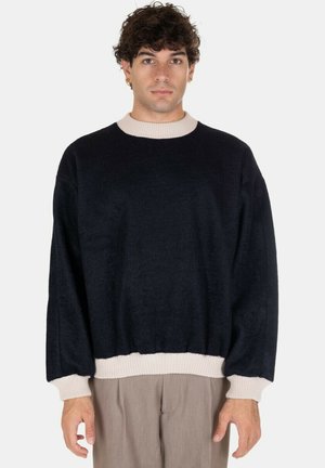 Maglione blu navy con colletto e polsini a costine crema; vestibilità rilassata e tessuto testurizzato; maniche lunghe; design semplice senza fantasie.