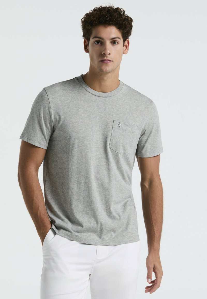 T-shirt en coton gris avec un col rond, des manches courtes et une poche poitrine arborant un petit logo. Texture lisse avec une coupe décontractée.