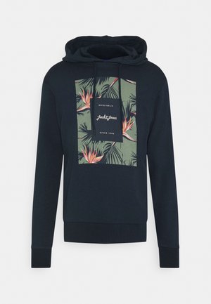 Hoodie bleu marine avec une poche kangourou, comportant un graphisme rectangulaire avec des feuilles et des fleurs tropicales en vert et en rose. Capuche avec cordon de serrage.