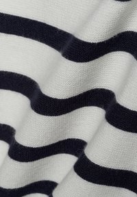 Strickstoff mit abwechselnd dicken navyblauen und weißen wellenförmigen Streifen, mit einer strukturierten Oberfläche und einem weichen Aussehen.