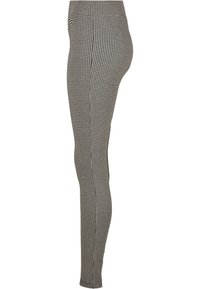 Fekete-fehér houndstooth leggings, slim fit szabással, rugalmas derékpánttal és sima textúrával, melyen végiglátható a minta.