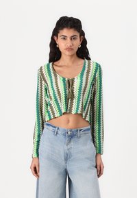 Horgolt cropped top, zigrábra mintázva zöld, fehér és barna színekben. Hosszú ujjak, elöl kötött részlettel és kerek nyakkivágással.
