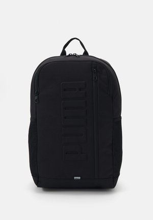 Mochila preta com tecido texturizado, grande logótipo em relevo, dois bolsos laterais em malha e fechos de zíper duráveis. Possui uma alça de transporte na parte superior.